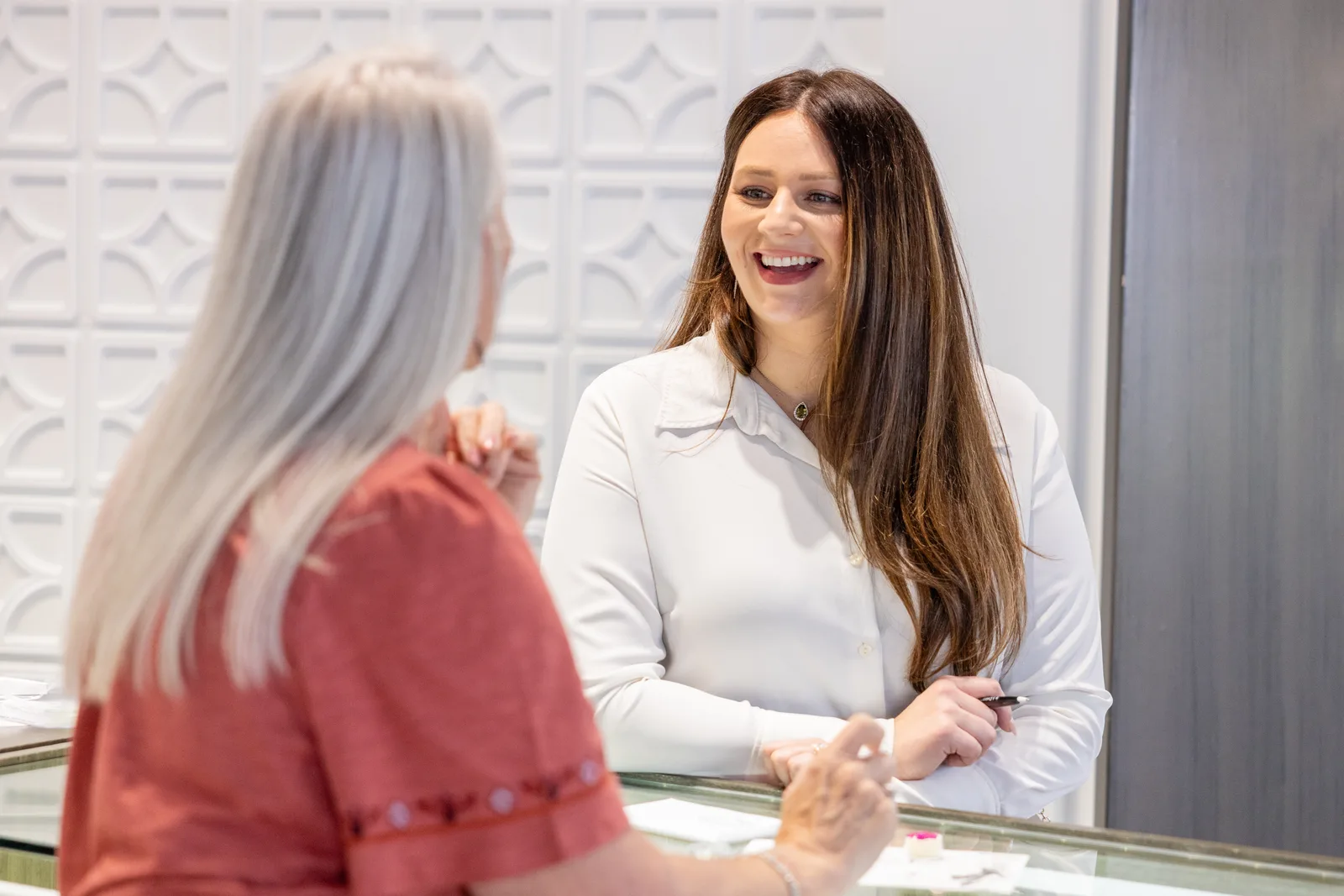 An associate laughing with a guest across the showroom case