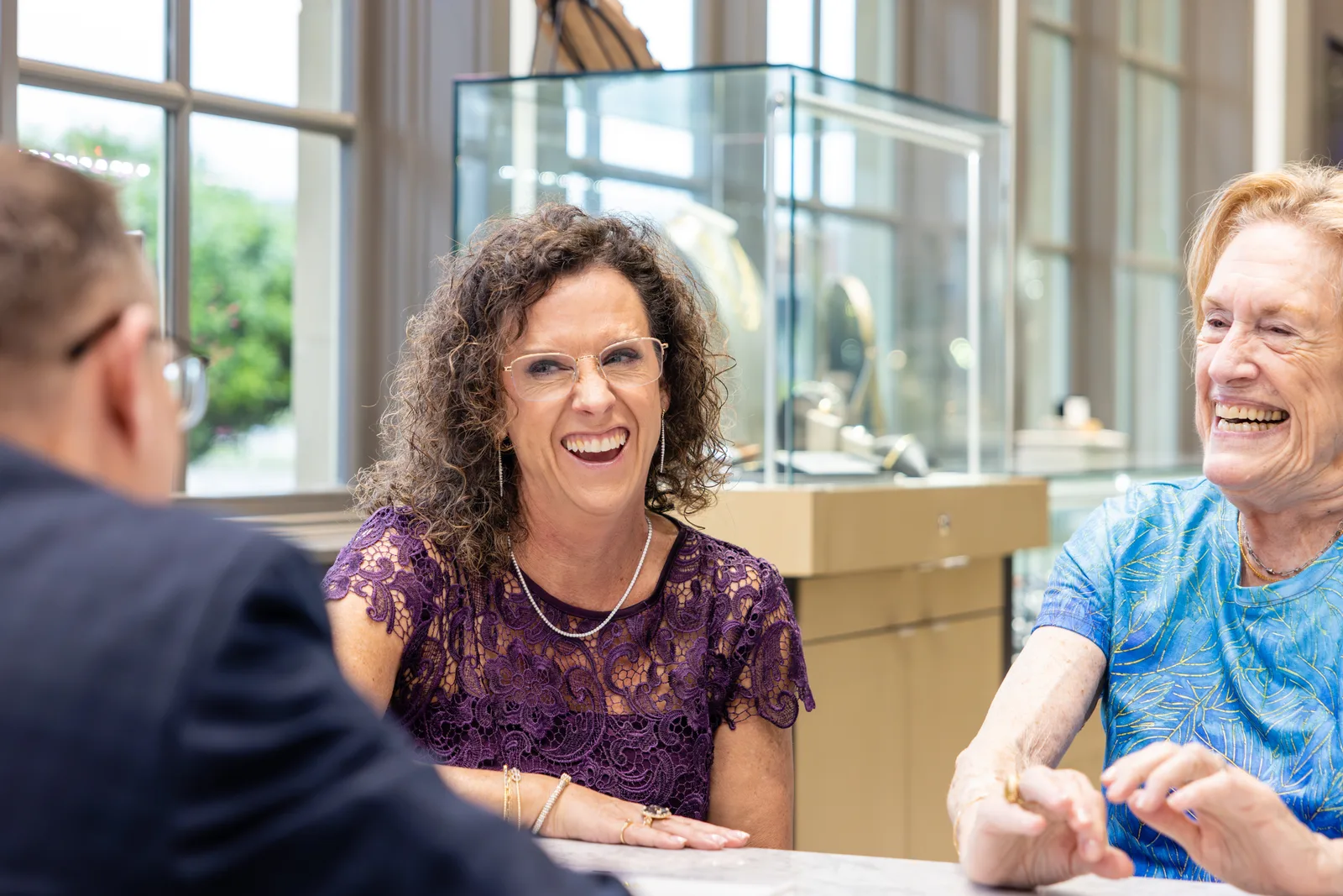 Two guests laughing at the design table with one of our team
