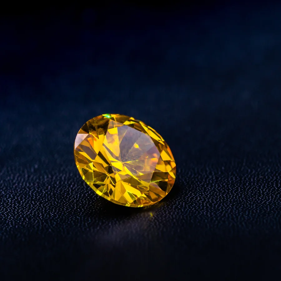 A yellow pear-shaped gem on a dark surface