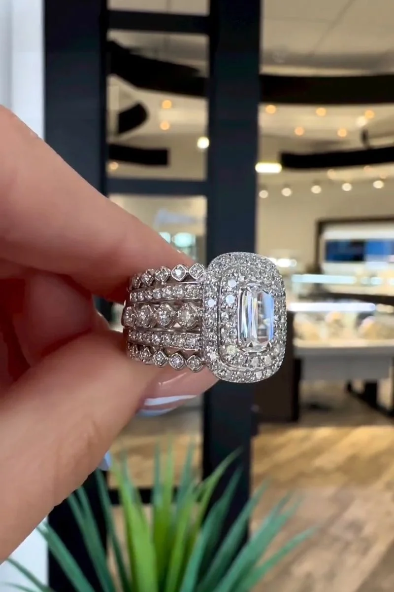 A handcrafted custom ring held between a jeweler's fingers at J. David Jewelry