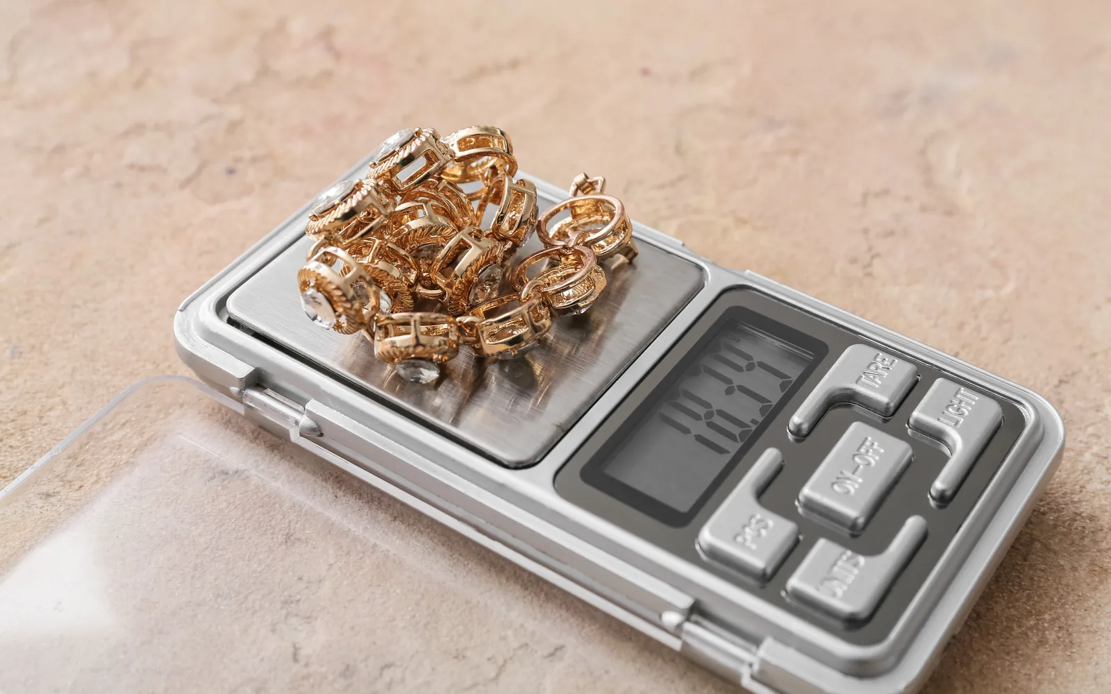 A pile of gold jewelry on a pocket scale