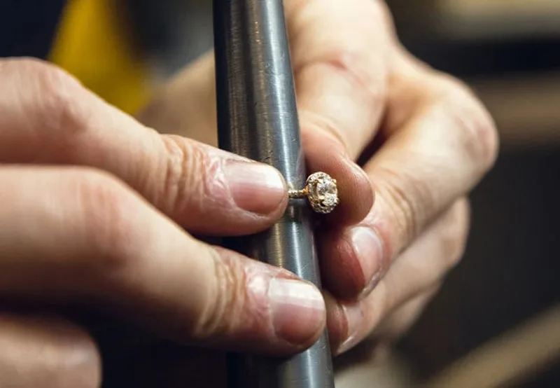 A ring sized between the jeweler’s fingertips