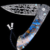 William Henry Knife B12 Blue Fusion, William Henry Knife The Spearpoint 'Blue Fusion' features a beautiful frame in hand forged 'X-Out' damascus by Chad Nichols. The handle is inlaid with a mesmerizing scale of 'Mammoth Fusion'. The blade is hand-forged '
