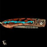 William Henry Knife The Spearpoint 'Chuska' features a beautiful frame in 'Twist' Mokume by Mike Sakmar, inlaid with vein turquoise. The blade is William Henry's signature 'Wave' damascus steel with VG-10 core. The one-hand button lock and the thumb stud