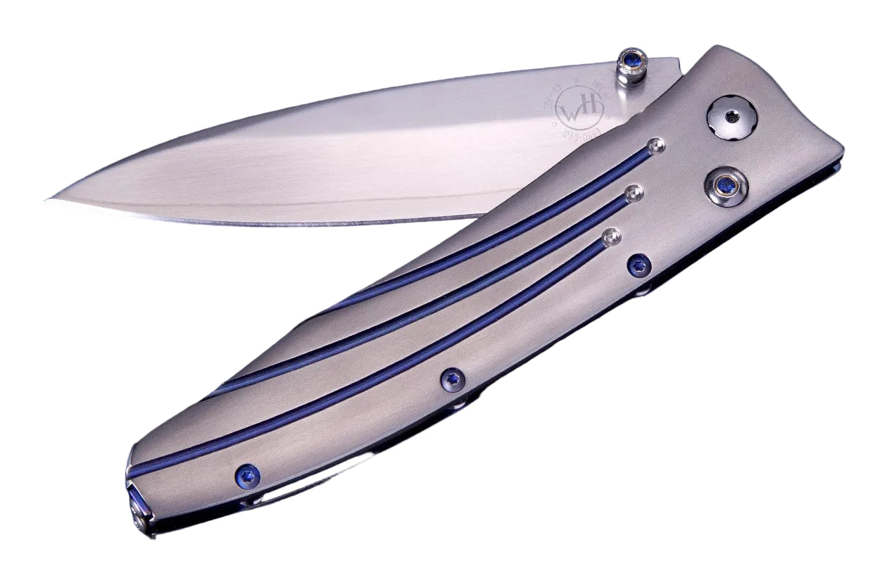 William Henry Knife The Gentac ‘Saturn II’ features a light and resilient frame in aerospace grade titanium, and anodized blue titanium pocket clip. The blade is extra-strong VG-10 core 'Wave' damascus; the one-hand button lock and the thumb stud are set