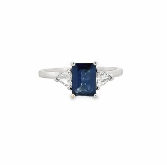 Platinum Three Stone Ring with a Emerald Cut Sapphire, and Trilliant Cut Diamonds