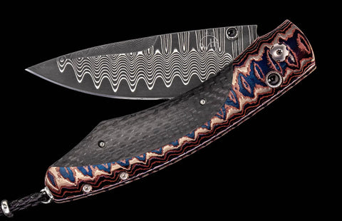 William Henry Knife The Spearpoint 'Midnight Sky' features a beautiful and unique frame in William Henry's signature (and patent pending) 'Wave' Mokume which has been inlaid with carbon fiber. The blade is crafted from 'Wave' damascus steel with an extra