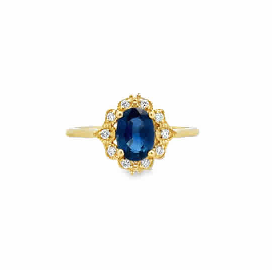 14 Karat Yellow Gold Vintage Inspired Ring with an Oval Cut Sapphire, and Round Brilliant Cut Diamonds