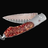 William Henry Knife The Spearpoint ‘Blend’ features a frame in aerospace-grade titanium, inlaid with a scale made from Pinot Noir chips. The blade is William Henry's signature 'Copper Wave' blade with a VG-5 core. The one-hand button lock and the thumb st