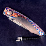 The Spearpoint 'Midnight Sky' William Henry Knife with 'Wave' Mokume Gane and Carbon Fiber Details, and 'Wave' Damascus Steel Blade.