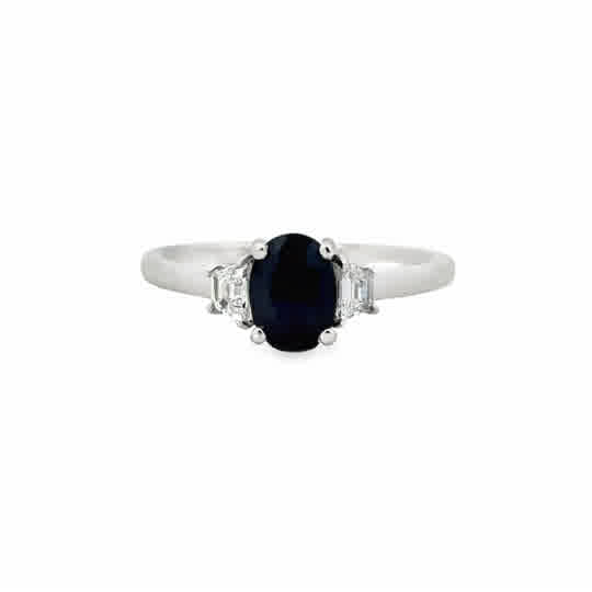 Platinum Three Stone Ring with an Oval Cut Sapphire, and Trapezoid Cut Diamonds